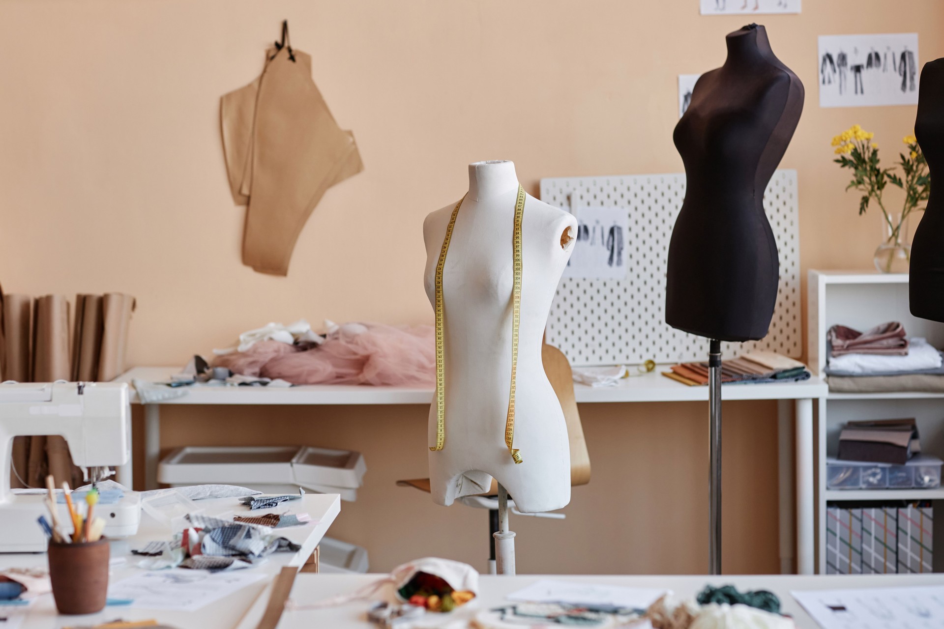 Part of spacious workshop of craftsperson with sewing equipment and mannequins