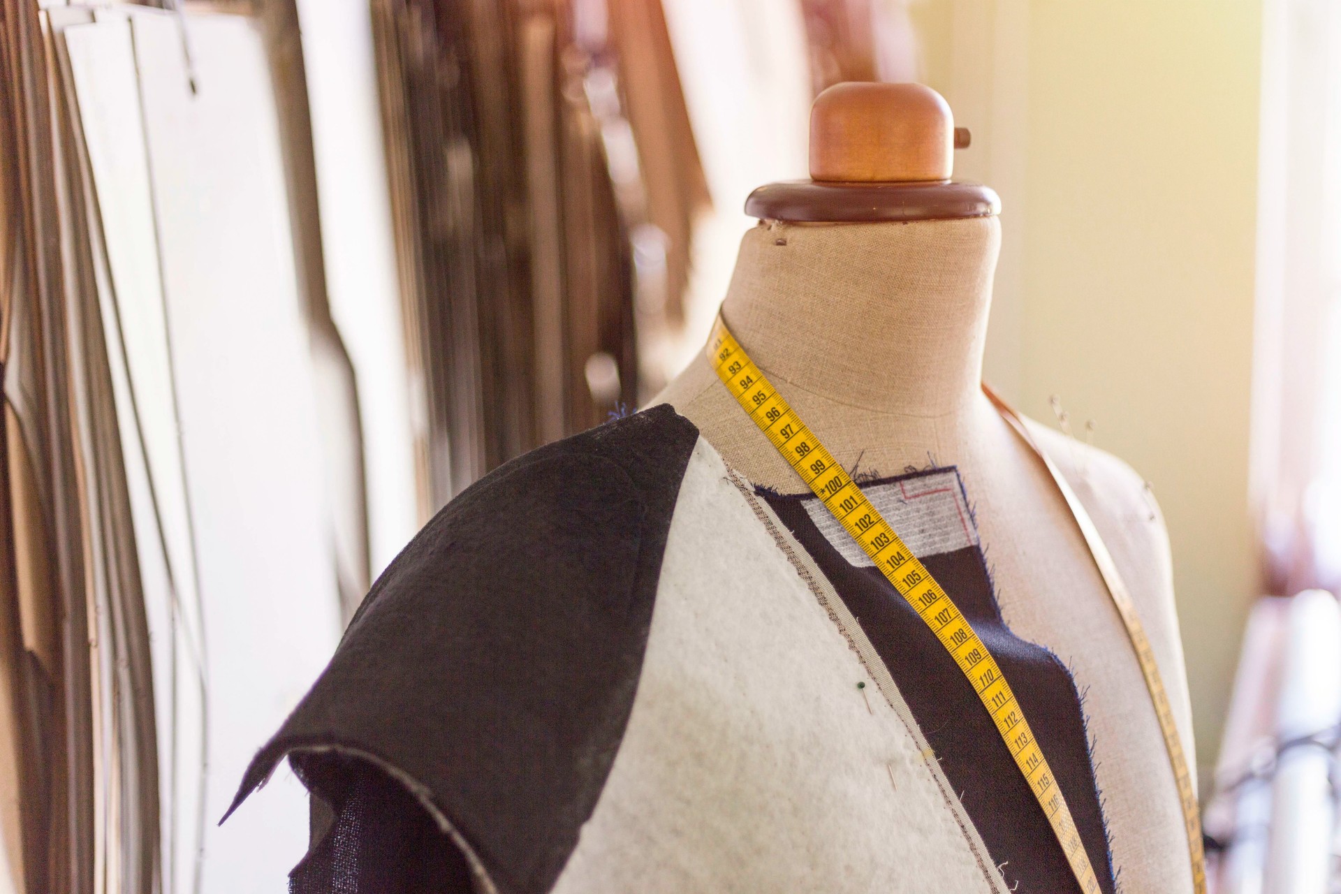 Tailored suit jacket on a mannequin during construction at bespoke tailor's workshop.